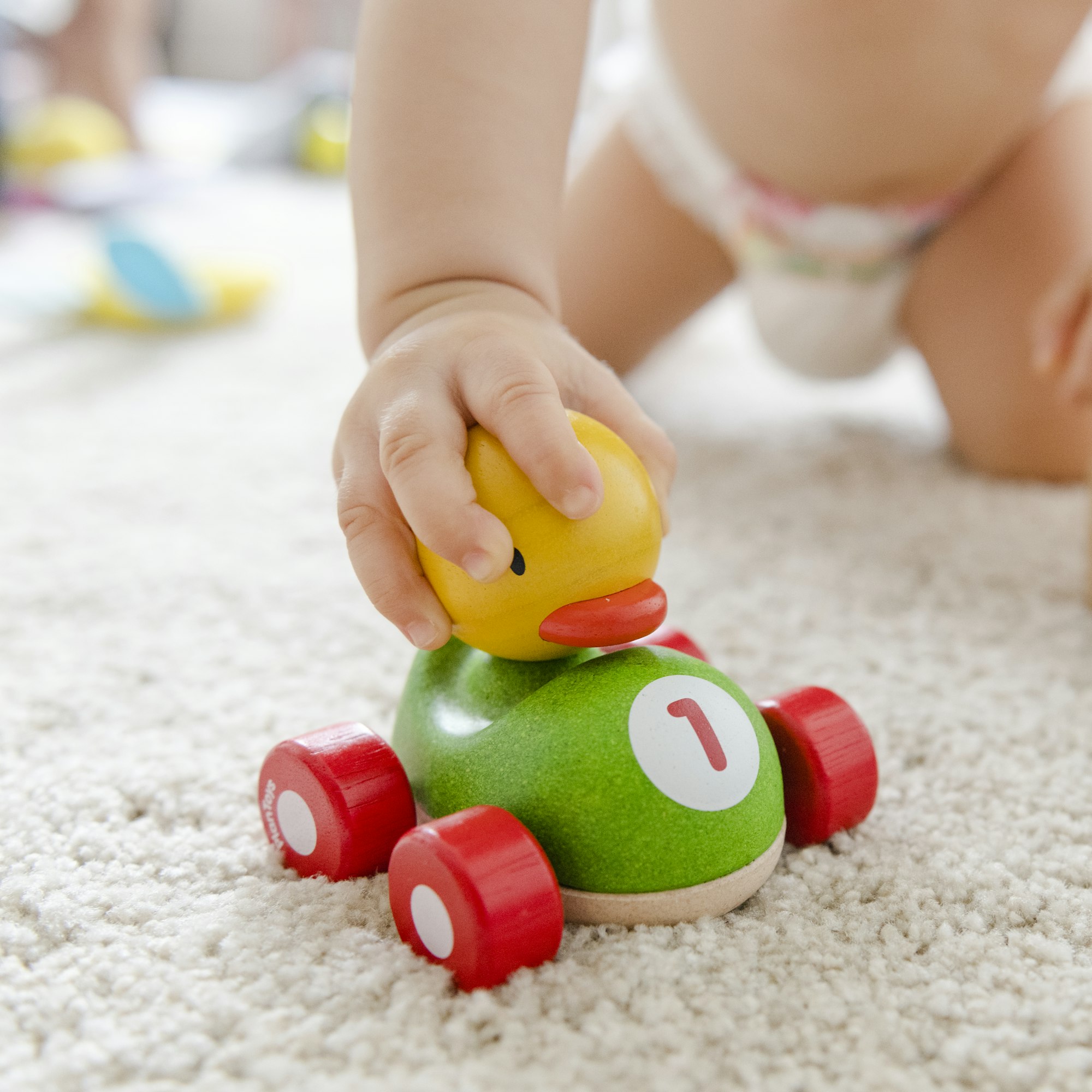 Baby playing with a wooden car
